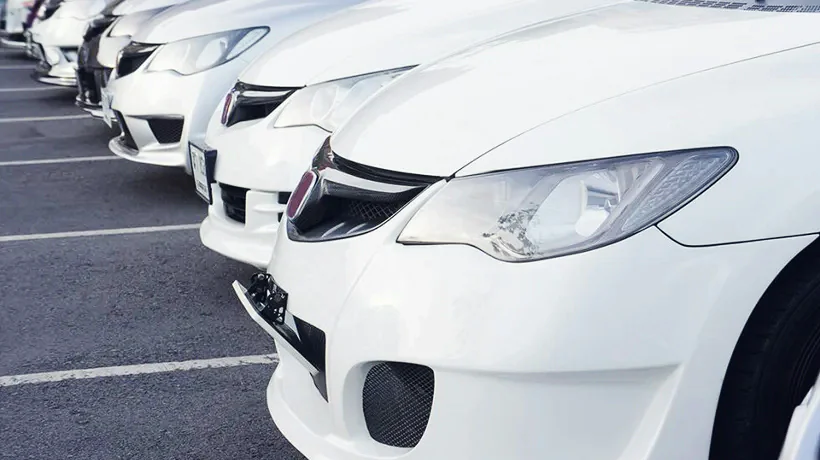 Otoparkta yan yana sıralanmış beyaz binek araçlar